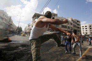 Palestinian protesters throw stones at Israeli troops during clashes over tension in Jerusalem's al-Aqsa mosque, in the occupied West Bank city of Hebron