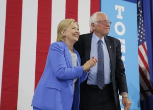 Democratic U.S. presidential candidates Clinton and Sanders stand together during campaign rally in Portsmouth, New Hampshire